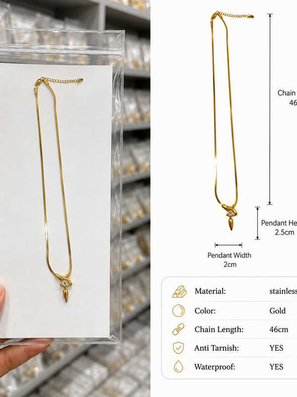 A gold stainless steel chain necklace with a decorative pendant, shown in a clear plastic display pouch held by a hand on the left, alongside a white dimension diagram on the right detailing the chain length of 46cm, pendant height of 2.5cm, and pendant width of 2cm.
